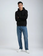 Heavyweight Pullover Hood P2016, a black fleece hoodie worn by a man with crossed arms and blue jeans.