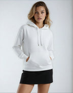 A blonde woman models the white Heavyweight Pullover Hood (Fleece) with her hands in the kangaroo pocket and a black skirt.